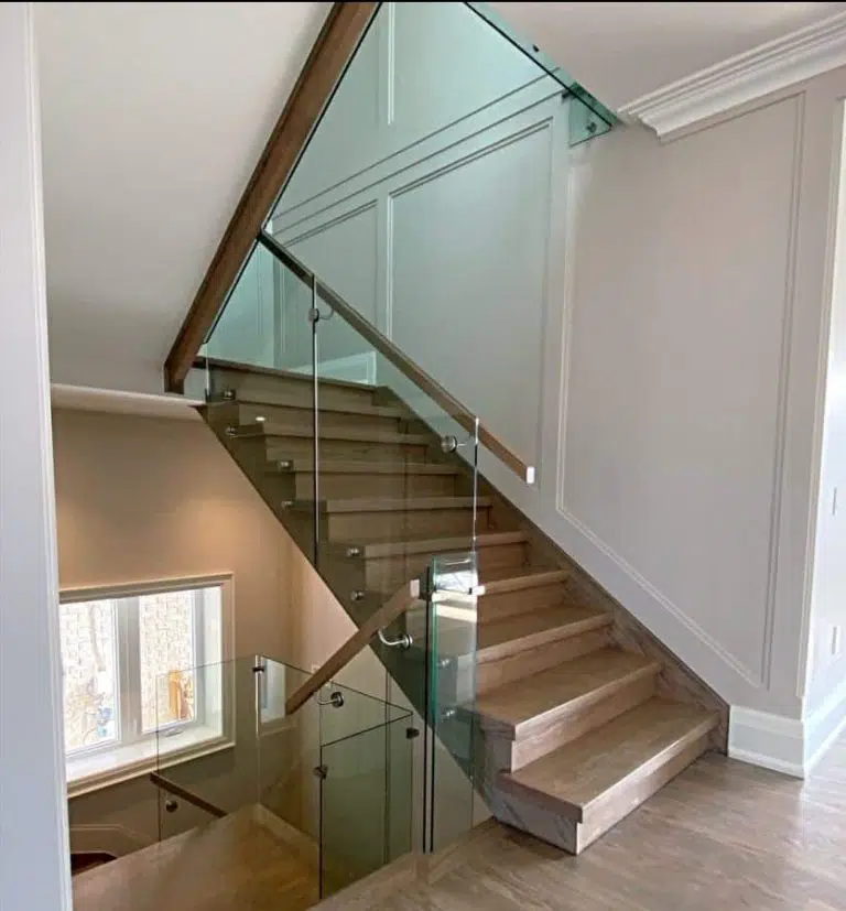 Glass Railing with Wood Handrail Glass railing with stainless steel standoffs and a wood handrail on an oak staircase, with matching glass along the landing
