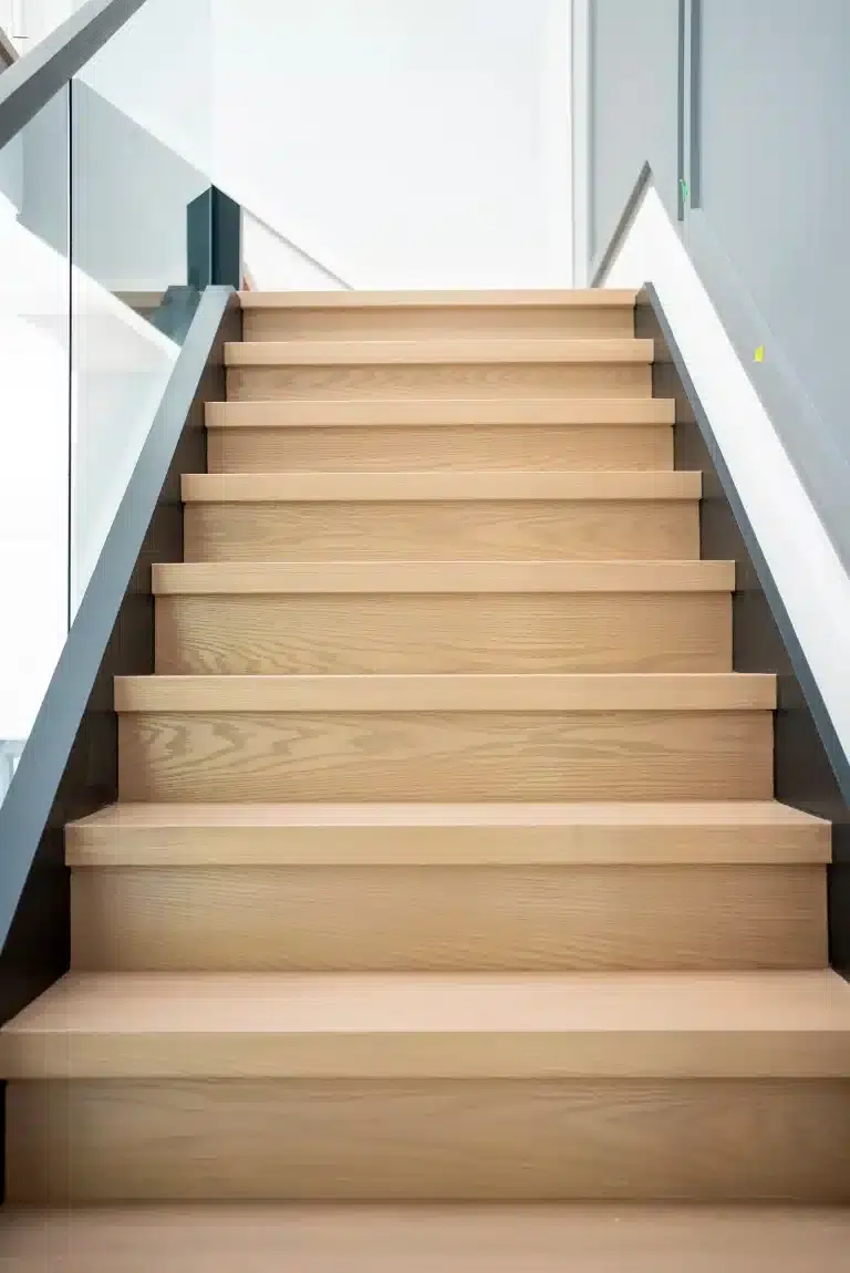 White Oak Stairs with Glass Railing Straight white oak staircase with a glass railing and grey handrail along the upper section