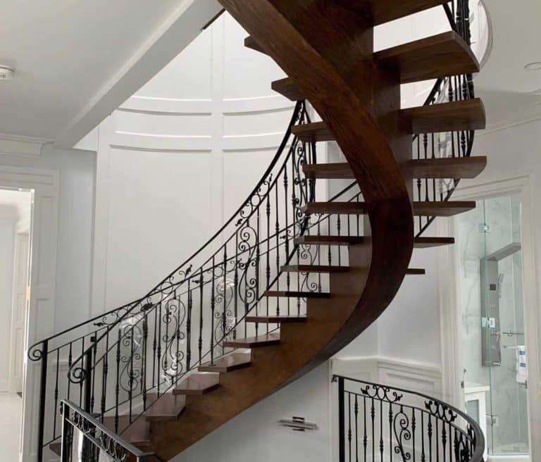curved wooden stairs with metal railing